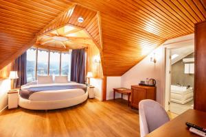 特拉布宗Zanike hotel的一间带一张大床的卧室,位于一个拥有木制天花板的房间