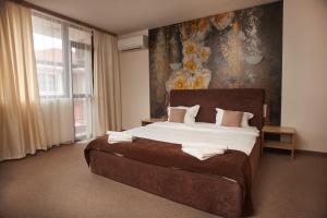 普罗夫迪夫Flamingo Plovdiv的一间卧室设有一张大床和大窗户
