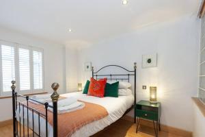 牛津Apartment in the heart of the city centre, live like a local的一间卧室配有带橙色和绿色枕头的床