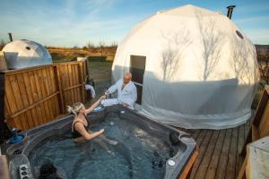 雷克雅未克Reykjavik Domes的坐在帐篷旁的热水浴池中的男女