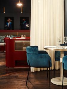 勒图凯-巴黎普拉日TRIBE Hôtel Le Touquet的一间配备有蓝色椅子和桌子的用餐室