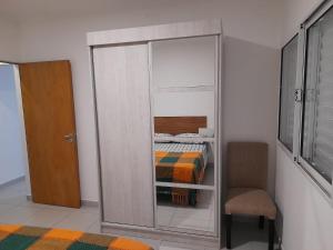 埃斯佩兰萨Departamento céntrico的一间卧室配有衣柜、一张床和一把椅子