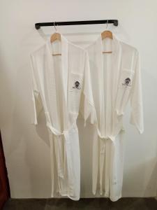 邦劳Bathala Resort的两件白色衬衫挂在架子上