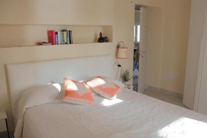 皮图朗格Case al mare di Cala Saccaia的卧室配有白色的床和两个枕头