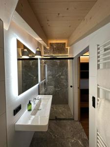 维尔德科格尔山麓布兰贝格Dorferwirt的一间带水槽和镜子的浴室