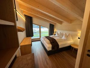 维尔德科格尔山麓布兰贝格Dorferwirt的一间卧室设有一张床和一个大窗户