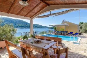 尼亚卢卡Villa Paradise的一座带木桌和游泳池的房子