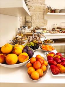 滨海波利尼亚诺Antico Mondo Rooms & Suites的自助餐,在柜台上盘子里放水果和蔬菜