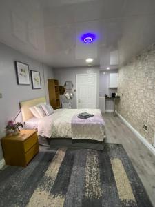 伯明翰Private bedroom near NEC, Birmingham airport,city centre的一间卧室配有一张大床和紫色灯