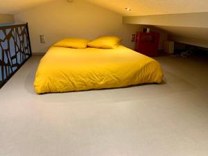MontcornetStudio à la campagne的一张带黄色床单和枕头的床