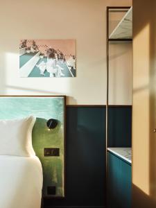 勒图凯-巴黎普拉日TRIBE Hôtel Le Touquet的卧室配有一张床,墙上挂有绘画作品