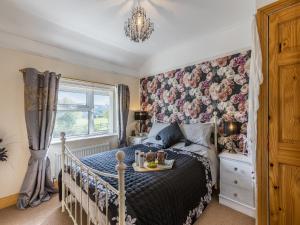西蒙兹亚特Flyby Cottage的一间卧室配有一张带花卉图案墙壁的床