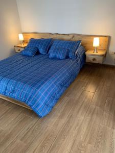 锡帕基拉Maravilloso chalet en la zona colonial (303)的一间卧室配有一张蓝色的床、枕头和两盏灯。