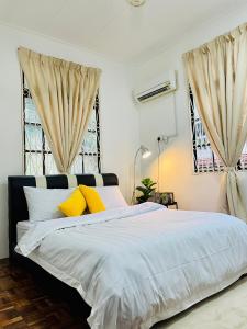 瓜埠QV Residence Langkawi - Jacuzzi, BBQ, & Steamboat的一间卧室配有一张带黄色枕头的大床