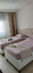 伊斯坦布尔Midtown Hotel Apartments 401 (2+1)的卧室内的3张床,配有粉红色床单