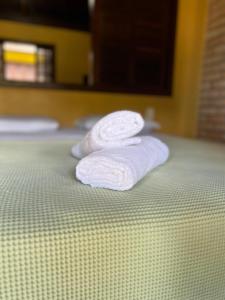 邦比尼亚斯Pousada Pacha Mama Village Bombinhas的床上有两条白色毛巾