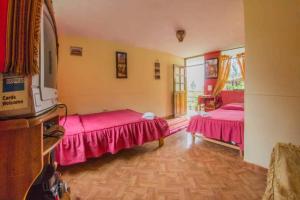 奥兰太坦波Secret Valley House Cusco的配有粉红色床单的客房内的两张床