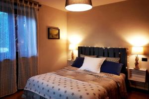 奥斯塔La maison de Carmen的一间卧室配有一张带两盏灯的床和一扇窗户。