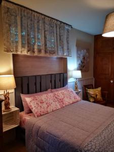 奥斯塔La maison de Carmen的一间卧室配有一张带粉色床单的床和一扇窗户。