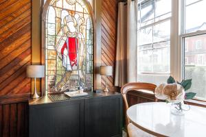 斯特拉福德Henry House - Patio Suite - An Arrivals Stay的一间设有桌子和彩色玻璃窗的用餐室