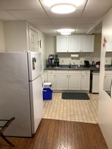 贾斯珀小熊旅馆的厨房配有白色橱柜和冰箱。