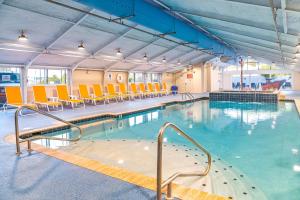 大洋城芬威克酒店 的大楼内带桌椅的大型游泳池