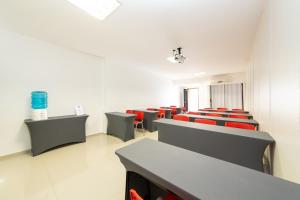 圣若泽Slim São José Zion的一间空的等候室,配有红色的椅子和书桌