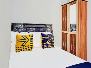 玛琅SPOT ON 1711 Serayu Sumbersari Residence的一张黄色和蓝色枕头的床