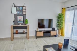 黑角Ravissant appartement 2ch à la plage的客厅配有平面电视和桌子。