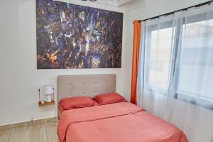 黑角Ravissant appartement 2ch à la plage的一间卧室配有一张带红色床单的床和一扇窗户。