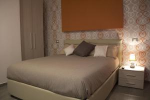 菲乌米奇诺幸福之家公寓的一间卧室配有一张床和一个带灯的床头柜