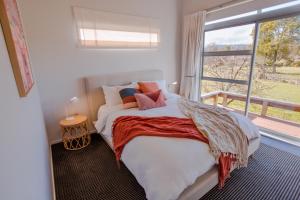 奥阿库尼Mountain Glass - Ohakune Holiday Home的一间卧室设有一张床和一个大窗户