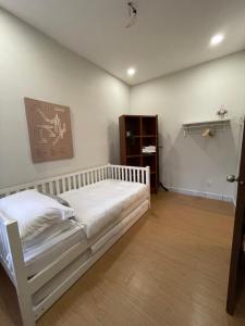 莎阿南sukebumie7的卧室配有白色的床,铺有木地板