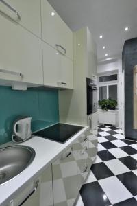 维也纳卢克斯尊贵公寓的厨房设有水槽和黑白格子地板。