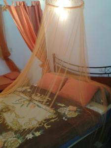 库塞尔Villa Carimo的一间卧室配有一张带天蓬和灯的床