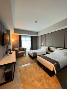 WonocoloBeSS Mansion Hotel Surabaya的酒店客房,设有两张床和一张沙发
