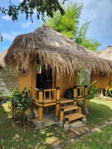 乌鲁瓦图巴厘岛生态别墅的一个带长凳和茅草屋顶的小小屋