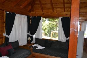 拉安戈斯图拉镇阿科尔曼山林小屋的带沙发和窗户的客厅