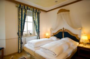 修希NaturResidence Dolomitenhof的一间卧室配有一张带白色床单的床和一扇窗户。