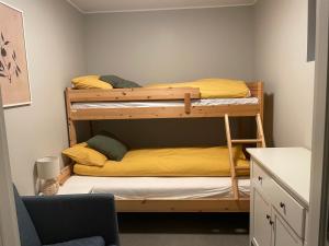 莫斯Ny Hybel leilighet med eget bad og egen inngang的小型客房配有两张双层床和椅子。