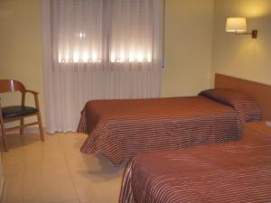 瑞达里那马略齐内斯旅馆的酒店客房,配有两张床和椅子