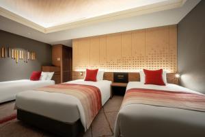 山形市山形大都会酒店的酒店客房,配有3张带红色枕头的床