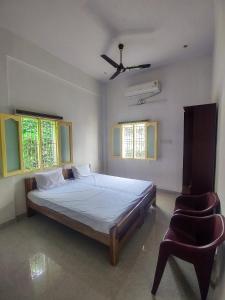 马杜赖Hotel Padma Shree , Madurai - Near Airport的一间卧室配有一张床和一把椅子