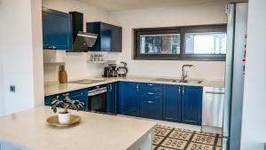 博德鲁姆Villa Çimentepe的厨房配有蓝色橱柜和水槽