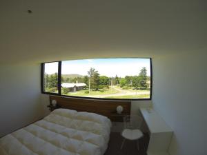 本塔纳山村Hoyo 6 Rincón del Golf的一间卧室设有一张床和一个大窗户