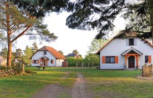 富伦多夫Awesome Home In Fuhlendorf With 4 Bedrooms And Wifi的白色的房子,有树和土路