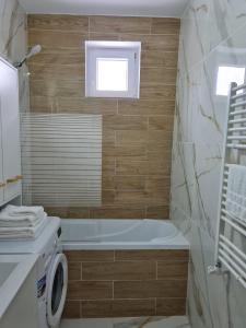 卡夫尼克DDDD Apartament的带浴缸和洗衣机的浴室。