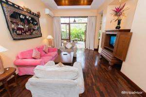 蒲甘泰拉巴之门酒店的客厅配有粉红色的沙发和电视