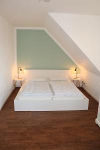 齐罗Auszeit am Meer的配有两张边桌的客房内的一张白色床