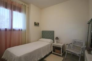 厄尔-汝姆披多Apartamento Familiar La Reserva的一间小卧室,配有一张床和一把椅子